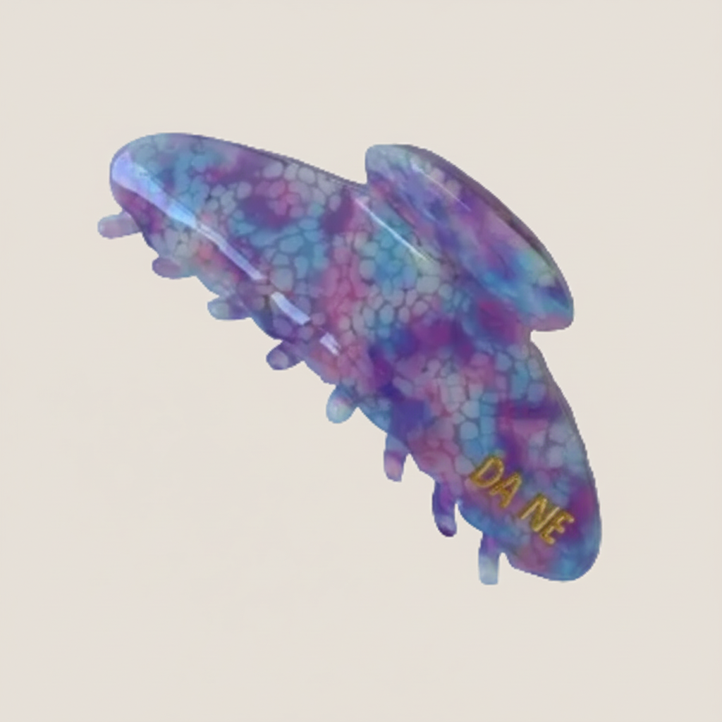 Colorful hair clip with 'Da Me' branding on a white background