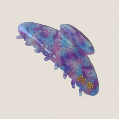 Colorful hair clip with 'Da Me' branding on a white background