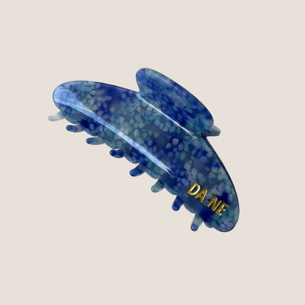Blue hair clip with 'DA NE' branding on a white background
