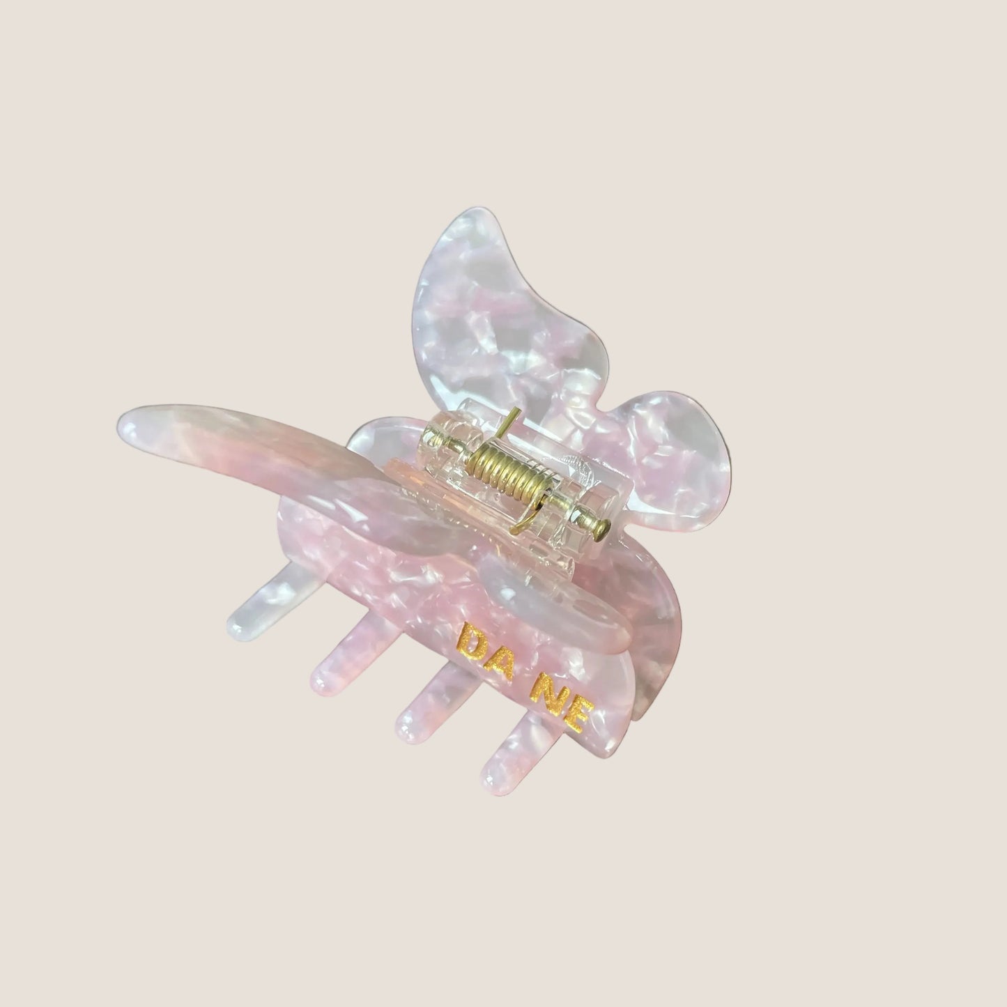 Pink hair clip with gold accents on a white background
