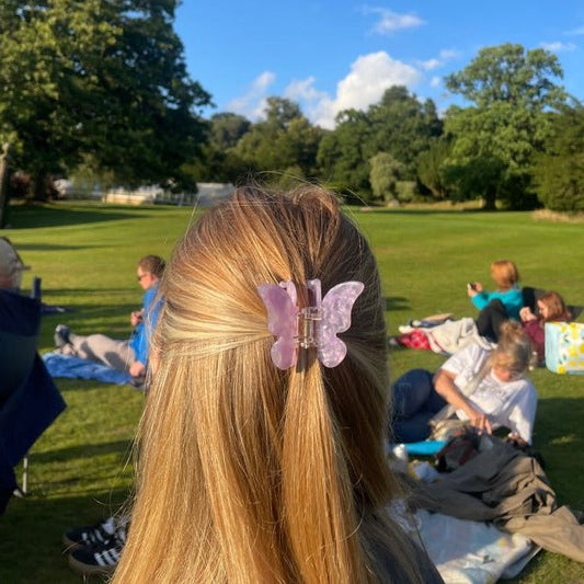 Person with a butterfly hair clip in a park setting